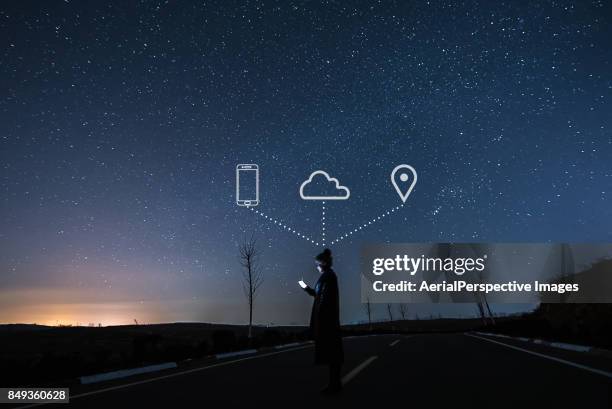 woman using smartphone in starry night - mobile phone reading low angle stock-fotos und bilder