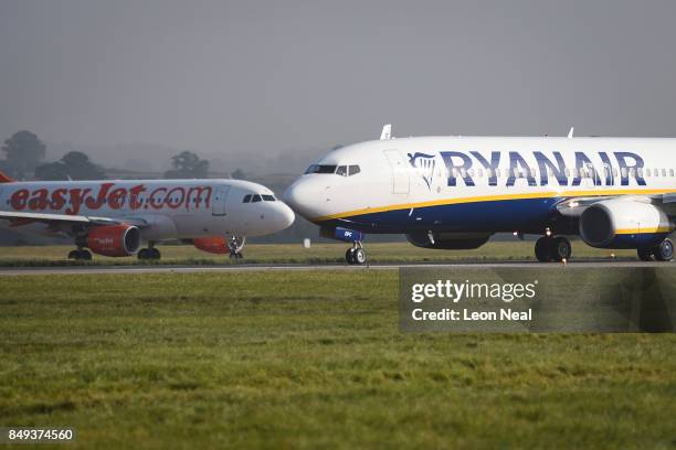 Ryanair passenger plane taxis past an Easyjet plane on the runway at Luton airport on September 19, 2017 in Luton, England. Passengers are facing...