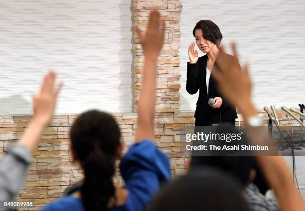Media reporters raise their hands to ask questions to lower house lawmaker Mayuko Toyota during a press conference after the meeting with her...