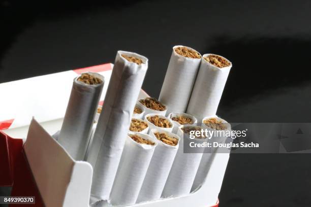 open pack of tobacco filled cigarettes - cigarette pack stockfoto's en -beelden