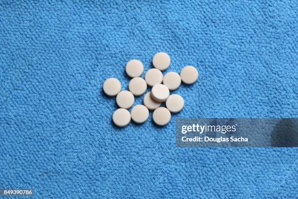 close up of health supplement pills on a blue background - anfetaminas fotografías e imágenes de stock