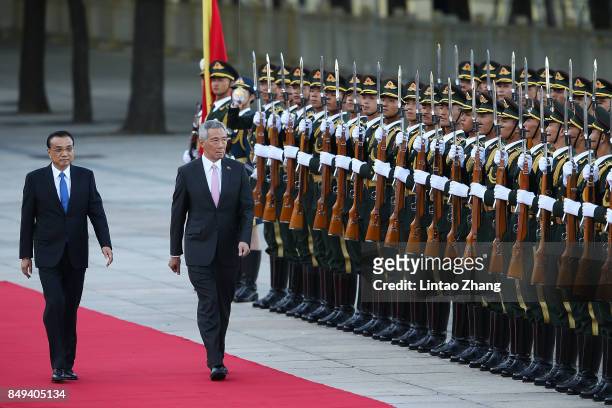 Chinese Premier Li Keqiang invites Singapore Prime Minister, Lee Hsien Loong to view a guard of honour during a welcoming ceremony outside the Great...