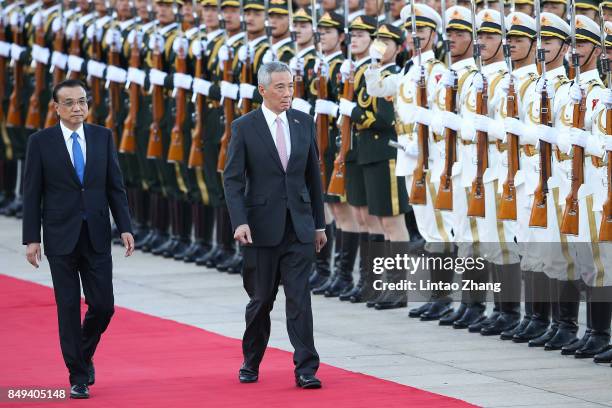 Chinese Premier Li Keqiang invites Singapore Prime Minister, Lee Hsien Loong to view a guard of honour during a welcoming ceremony outside the Great...