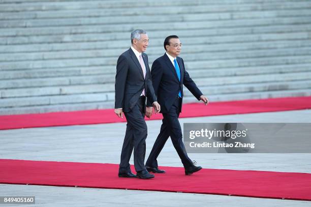 Chinese Premier Li Keqiang invites Singapore Prime Minister, Lee Hsien Loong to view a guard of honour during a welcoming ceremony outside the Great...