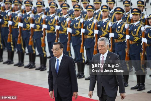 Chinese Premier Li Keqiang invites Singapore Prime Minister, Lee Hsien Loong to view a guard of honour during a welcoming ceremony outside the Great...
