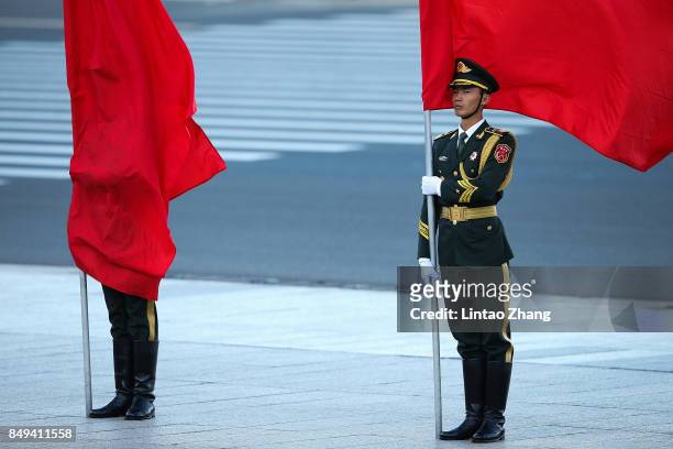 The wind blows a red flag onto the face of an honour guard during a welcoming ceremony for Singapore Prime Minister, Lee Hsien Loong outside the...