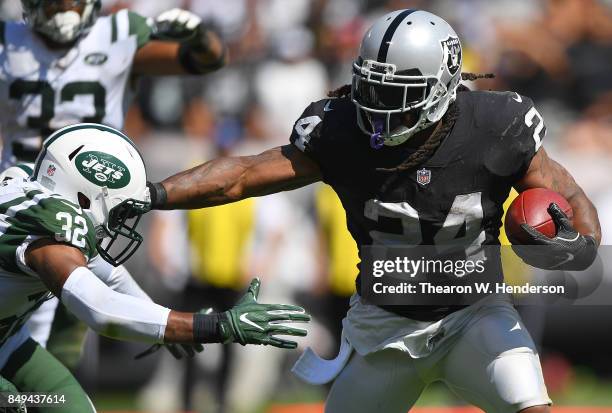 Marshawn Lynch of the Oakland Raiders breaks the tackle of Juston Burris of the New York Jets during the second quarter of their NFL football game at...