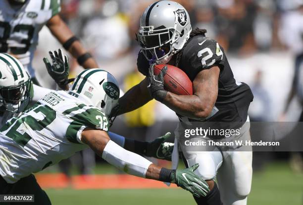 Marshawn Lynch of the Oakland Raiders breaks the tackle of Juston Burris of the New York Jets during the second quarter of their NFL football game at...