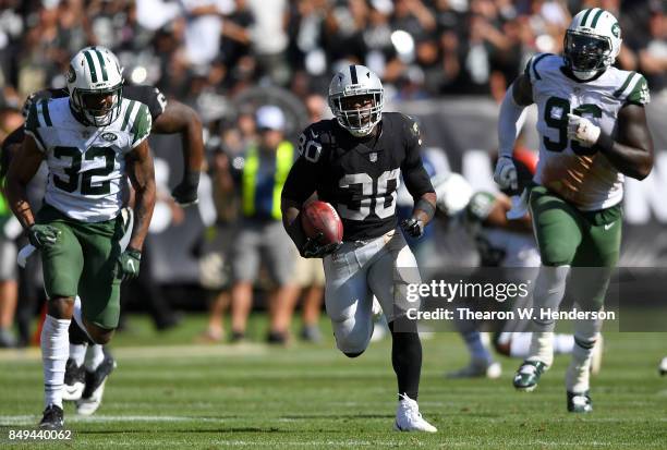 Jalen Richard of the Oakland Raiders scores on a 52 yard touchdown run while pursued by Juston Burris of the New York Jets during the fourth quarter...