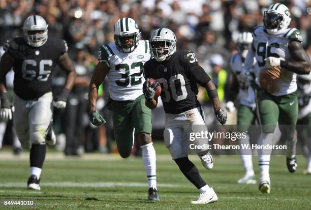 Jalen Richard of the Oakland Raiders scores on a 52 yard touchdown run while pursued by Juston Burris of the New York Jets during the fourth quarter...