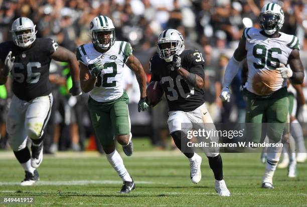 Jalen Richard of the Oakland Raiders scores on a 52 yard touchdown run while pursued by Juston Burris of the New York Jets during the fourth quarter...