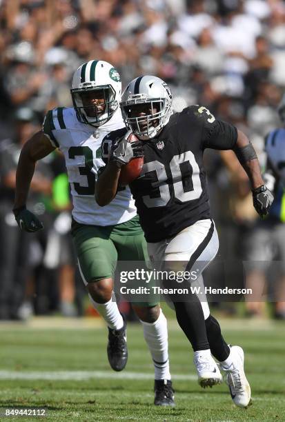 Jalen Richard of the Oakland Raiders scores on a 52 yard touchdown run while pursued by Juston Burris of the New York Jets during the fourth quarter...