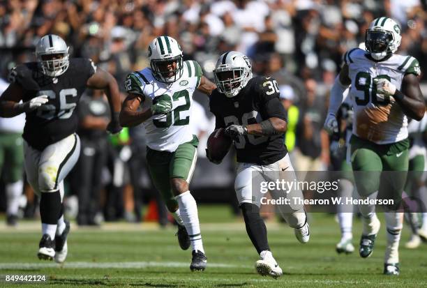 Jalen Richard of the Oakland Raiders scores on a 52 yard touchdown run while pursued by Juston Burris of the New York Jets during the fourth quarter...