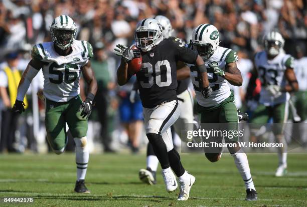 Jalen Richard of the Oakland Raiders scores on a 52 yard touchdown run while pursued by Juston Burris of the New York Jets during the fourth quarter...