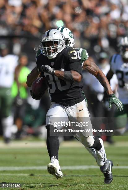 Jalen Richard of the Oakland Raiders scores on a 52 yard touchdown run while pursued by Juston Burris of the New York Jets during the fourth quarter...