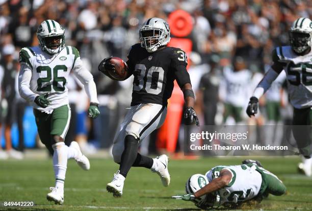 Jalen Richard of the Oakland Raiders scores on a 52 yard touchdown run while pursued by Juston Burris of the New York Jets during the fourth quarter...