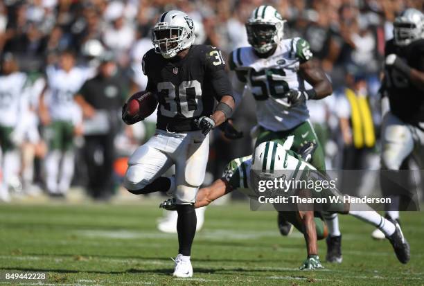 Jalen Richard of the Oakland Raiders scores on a 52 yard touchdown run while pursued by Juston Burris of the New York Jets during the fourth quarter...