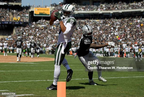 Jermaine Kearse of the New York Jets catches a thirty four yard touchdown pass over David Amerson of the Oakland Raiders during the second quarter of...