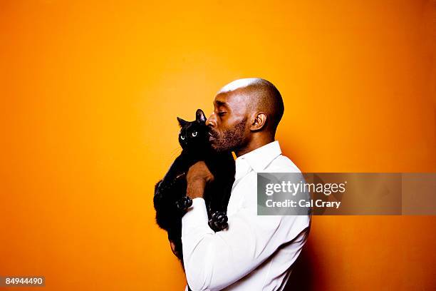 african-american man holding a black cat. - i love new york fotografías e imágenes de stock