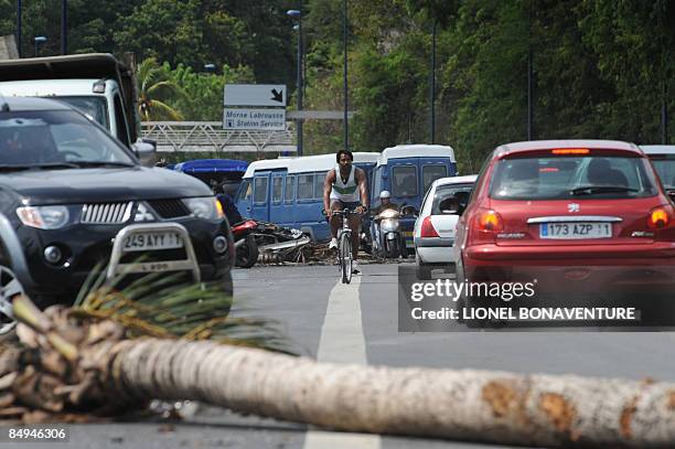 Locals try to pass by a barricade on February 20, 2009 in Pointe-a-Pitre, on the French Caribbean island of Guadeloupe, on a urban motorway littered...