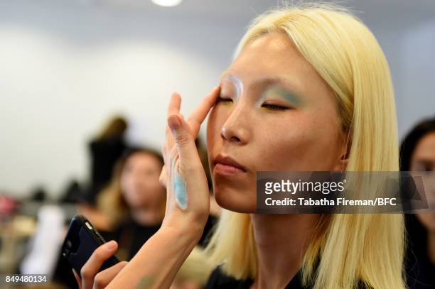 Model has makeup applied backstage ahead of the palmer//harding show during London Fashion Week September 2017 on September 19, 2017 in London,...