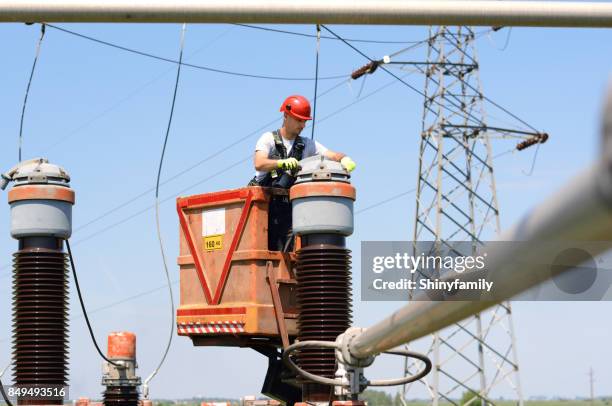electrician fixing power lines in power substation. working in high. - rede elétrica imagens e fotografias de stock