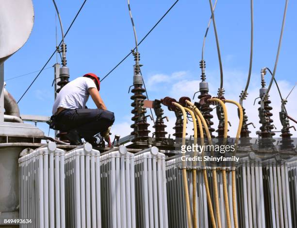 electrician working on high voltage transformer in power station - high voltage sign stock pictures, royalty-free photos & images