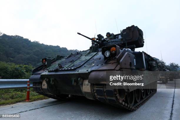 Army armored vehicles travel along a road during Warrior Strike VIII, a bilateral training exercise between the U.S. Army's 2nd Armored Brigade...
