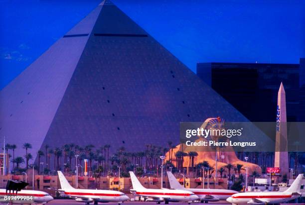 editorial use : telephoto perspective - louxor hotel and parking lot busy with airline jets, near las vegas international airport, usa - las vegas pyramid stock pictures, royalty-free photos & images