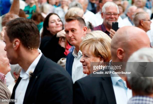 German Chancellor and Christian Democratic Union's main candidate Angela Merkel wawalks past supporters as she arrives at an election rally in...