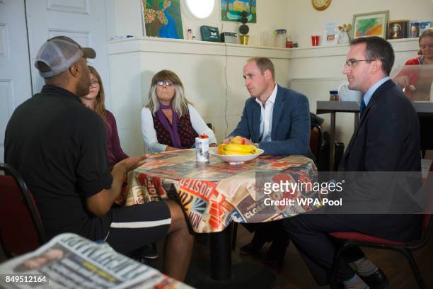 Prince William, Duke of Cambridge speaks with people in the drop in cafe which is geared toward helping the homeless during a visit to the...