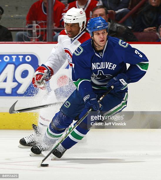 Georges Laraque of the Montreal Canadiens looks on as Kevin Bieksa of the Vancouver Canucks carries the puck up ice during their game at General...