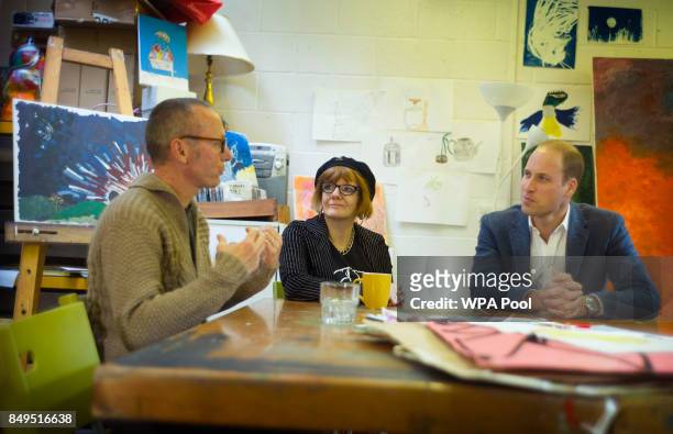 Prince William, Duke of Cambridge speaks with former clients Jason, Heather and Grace in the art room where clients can undergo a series of art...