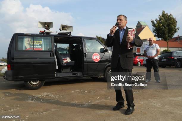 Udo Pastoers, a member of the far-right NPD political party, speaks outside the venue where German Chancellor and Christian Democrat Angela Merkel...