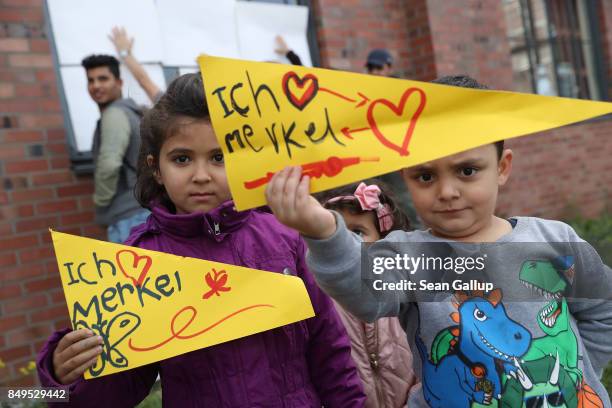 Refugee children from Syria hold up signs that read: "I love Merkel" in reference to German Chancellor and Christian Democrat Angela Merkel as they...