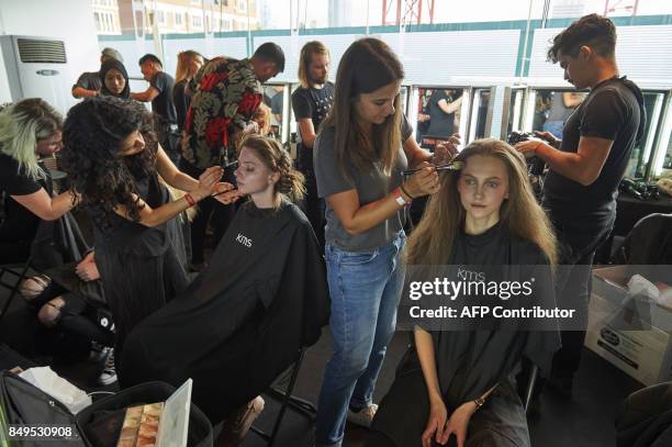 Models are prepared by stylists backstage ahead of the catwalk show by Turkish designer Bora Aksu, for his Spring/Summer 2018 collection on the first...