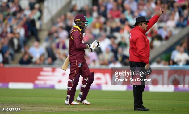 West Indies batsman Marlon Samuels leaves the field as umpire Tim Robinson gives him out after review during the 1st Royal London One Day...
