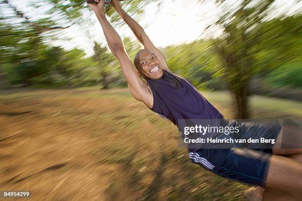 man swinging on a swing in the park. pietermaritzburg, kwazulu-natal province, south africa - freek van den bergh stock pictures, royalty-free photos & images