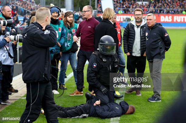 Olaf Janssen, head coach St. Pauli reacts while a supporter of Kiel is arrested by the police the Second Bundesliga match between Holstein Kiel and...