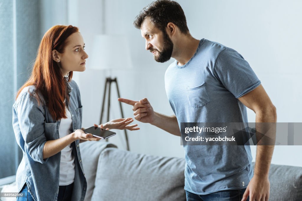 Angry upset man pointing at his wife