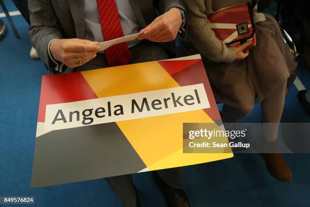 An onlooker holds a sign on his lap prior to the arrival of German Chancellor and Christian Democrat Angela Merkel at an election campaign stop on...