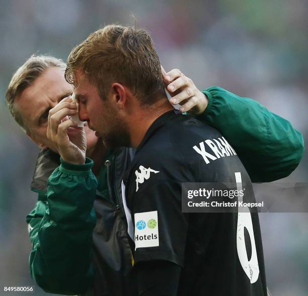 Christoph Kramer of Moenchengladbach gets treated for an injury by Dr. Stefan Hertl during the Bundesliga match between Borussia Moenchengladbach and...