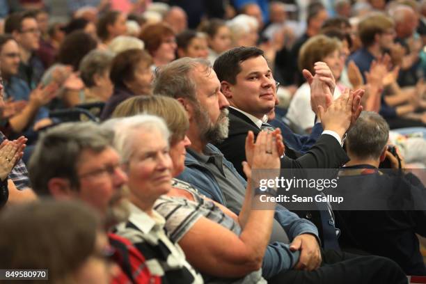 People listen to German Chancellor and Christian Democrat Angela Merkel speak at an election campaign stop on September 19, 2017 in Schwerin,...