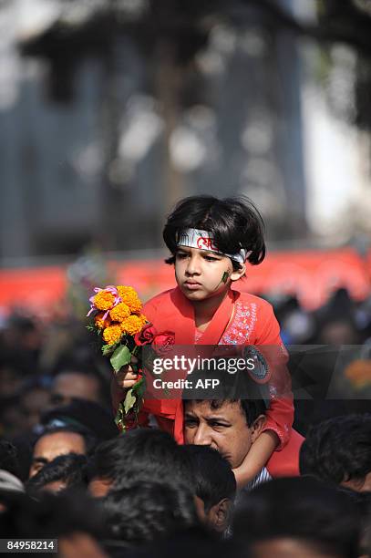 Bangladeshi girl participates in a rally near the monument for Bangladesh's Language Movement martyrs in Dhaka on February 21 to pay homage to the...