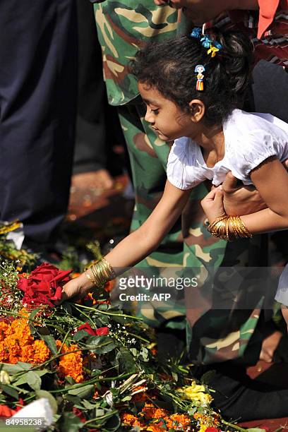 Bangladeshi girl lays flowers on the monument for Bangladesh's Language Movement martyrs in Dhaka on February 21 to pay homage to the martyrs of the...