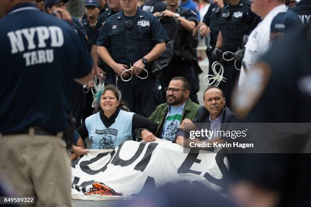 Activists, including Congress member Luis Gutierrez, at right, sit on Fifth Avenue in an action of civil disobedience near Trump Tower on September...