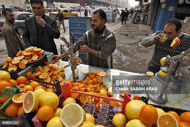 An Iraqi vendor presses citrus fruit at his stand along a main shopping street in Baghdad on February 21 2009.The fruit are grown in orchards in the...