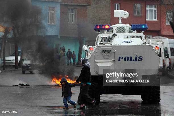 Woman and her son passes by a riot police water cannon vehicle after a demonstration to protest Turkish Prime Minister Recep Tayyip Erdogan's...