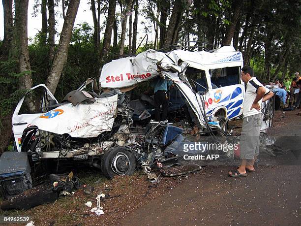 Man watches the wreckage of a tourism minibus that collided with a van while travelling from Ciudad del Este towards Asuncion near the city of Leon...
