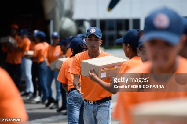 Members of the Venezuelan Civil Protection load supplies with humanitarian aid for the island of Dominica after the Caribbean island was battered by...